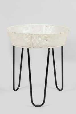 un gros plan sur une table blanche aux pieds noirs, sur laquelle est posé un panier