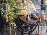 une table et des chaises devant un mur sur lequel est accrochée une peinture