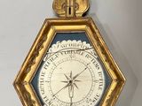 une vieille horloge accrochée au mur, dans un cadre doré