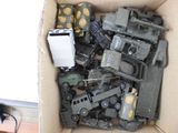 a cardboard box filled with toy army vehicles and a cell phone