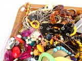un plateau en bois rempli de bijoux variés, posé sur une table
