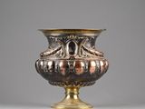a silver and gold vase sitting on a table