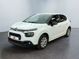 Une Citroën blanche est garée dans une pièce blanche