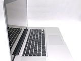 a silver laptop with a black keyboard on a white surface