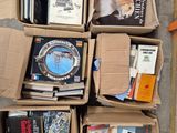 Plusieurs cartons remplis de livres sont empilés les uns à côté des autres sur le sol.