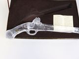 a glass gun in a box on a table