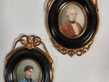two framed portraits of a man and a woman are hanging on a wall