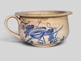an old blue and white cup with a bird on it