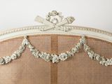 an image of a bed with a white headboard and wicker
