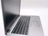 a silver laptop with a black keyboard on a white surface