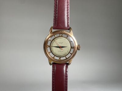 une image montrant un gros plan d'une montre-bracelet avec un bracelet rouge