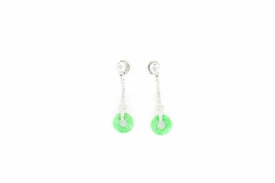 une paire de boucles d'oreilles vertes et blanches sur fond blanc