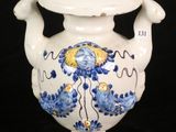 a white vase with a blue and yellow design on it