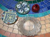 trois assiettes et une bougie posées sur une table en mosaïque