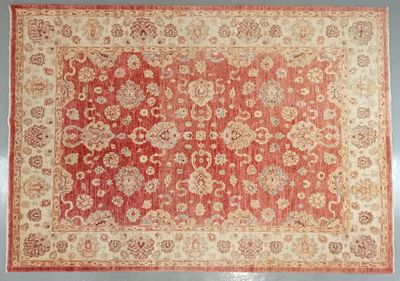 a red and beige rug with a floral design on it