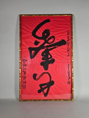 un tableau rouge et noir avec des caractères chinois sur un mur blanc