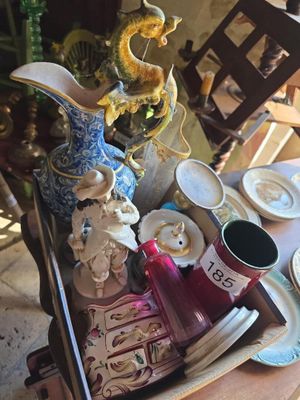 un plateau avec des assiettes, des tasses et des vases posé sur une table