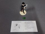 a figurine of a man sitting on a chair next to a card