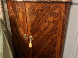 a wooden cabinet with a marble top next to a bed