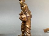 two bronze figurines of a man holding a rifle and a gun