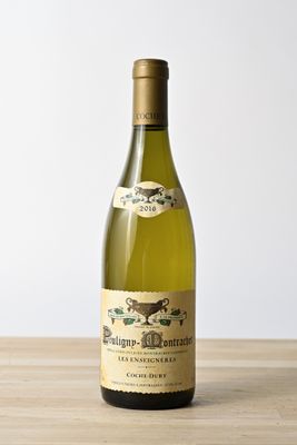 the bottle of white wine is sitting on a wooden table