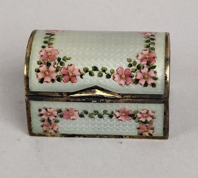une boîte blanche ornée de fleurs roses, posée sur une table