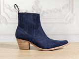 a pair of blue sued ankle boots on a wooden table