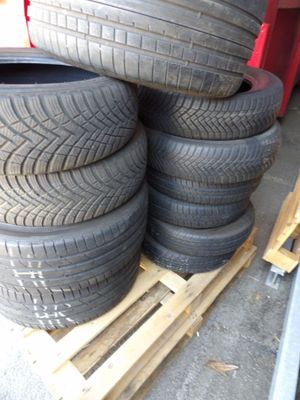 des pneus empilés sur une palette dans un garage aux murs rouges