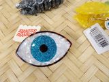a close up of a blue eye brooch on a table