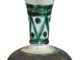 a green and white vase sitting on a white surface