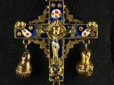 an image of a cross with bells hanging from it ' s side
