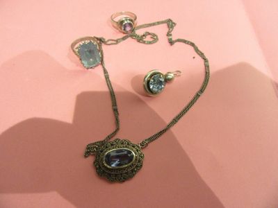 a necklace and earring set on a pink surface