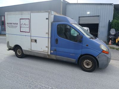 un camion bleu et blanc garé devant un immeuble