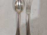 deux fourchettes et une cuillère posées sur une nappe blanche