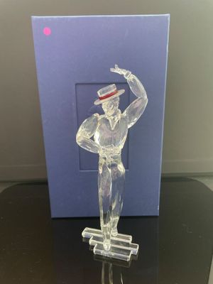figurine représentant un homme en haut-de-forme et en costume, posée sur une table