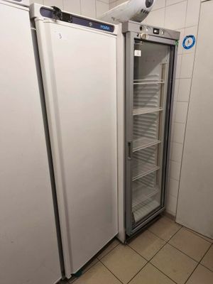 two refrigerators that are next to each other in a room