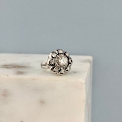 un gros plan d'une bague en diamant posée sur un bloc de marbre