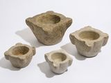 quatre morceaux de pierre sont disposés en ligne sur une surface blanche