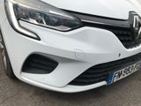 the front end of a white car parked on the side of the road