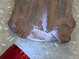 a small statue of a cat sitting on a plastic bag