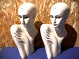 deux têtes de mannequin blanches posées sur une surface bleue