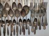 a lot of silver spoons and forks on the table