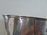 a silver bowl with a handle on a table