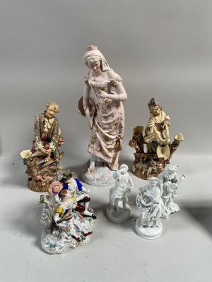 cinq figurines posées sur une table, sur fond blanc