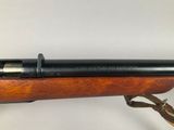 a rifle with a wooden barrel and a black handle