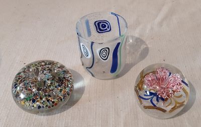 trois objets en verre posés les uns à côté des autres sur une table
