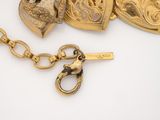 several pieces of gold jewelry on a white surface