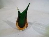 un vase vert et jaune posé sur une table blanche