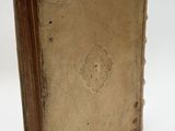 an old book sitting on top of a white table next to a white wall