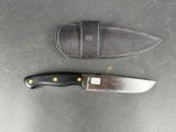 a knife that is laying next to a knife sheath